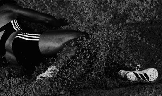Long jumper landing in the sand pit